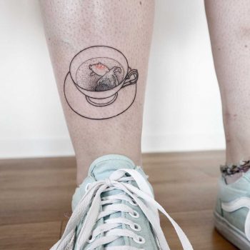 Goldfish in a teacup tattoo by Ann Gilberg