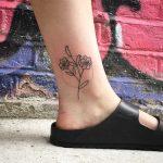 Hand-poked flower tattoo on an ankle by Kirk Budden