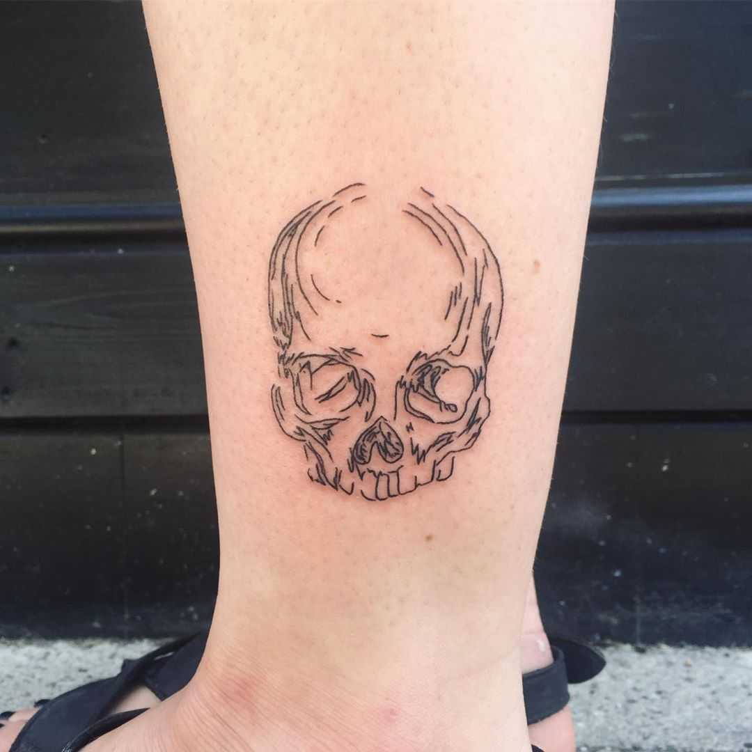 Skull on an ankle by Suki Lune