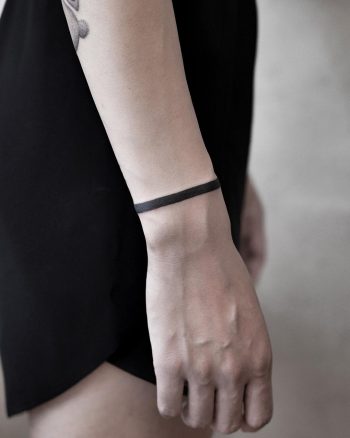 Solid black bracelet tattoo by Aki Wong