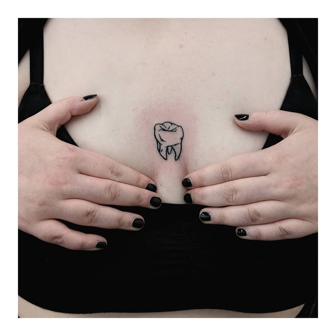 Tooth tattoo located on the wrist, illustrative style.