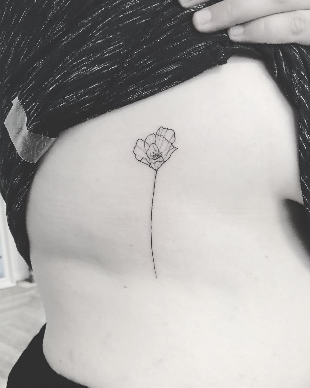 A thin poppy tattoo by Annelie Fransson