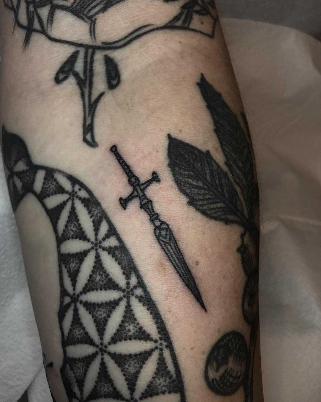 Micro dagger tattoo by Tine DeFiore