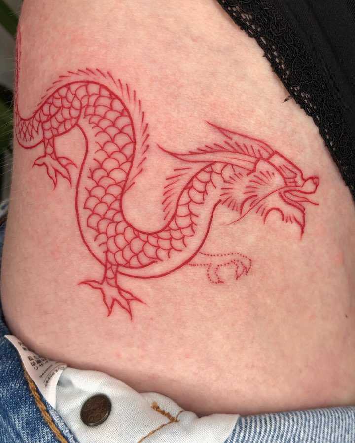 Red dragon tattoo on a hip by Loz Thomas
