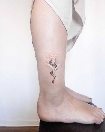 Snake and white lily tattoo by Ann Gilberg