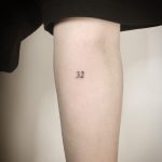Tiny number 32 tattoo by Kirk Budden