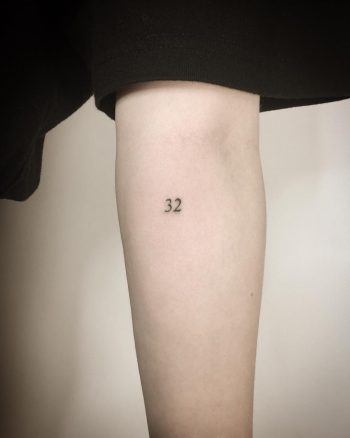 Tiny number 32 tattoo by Kirk Budden