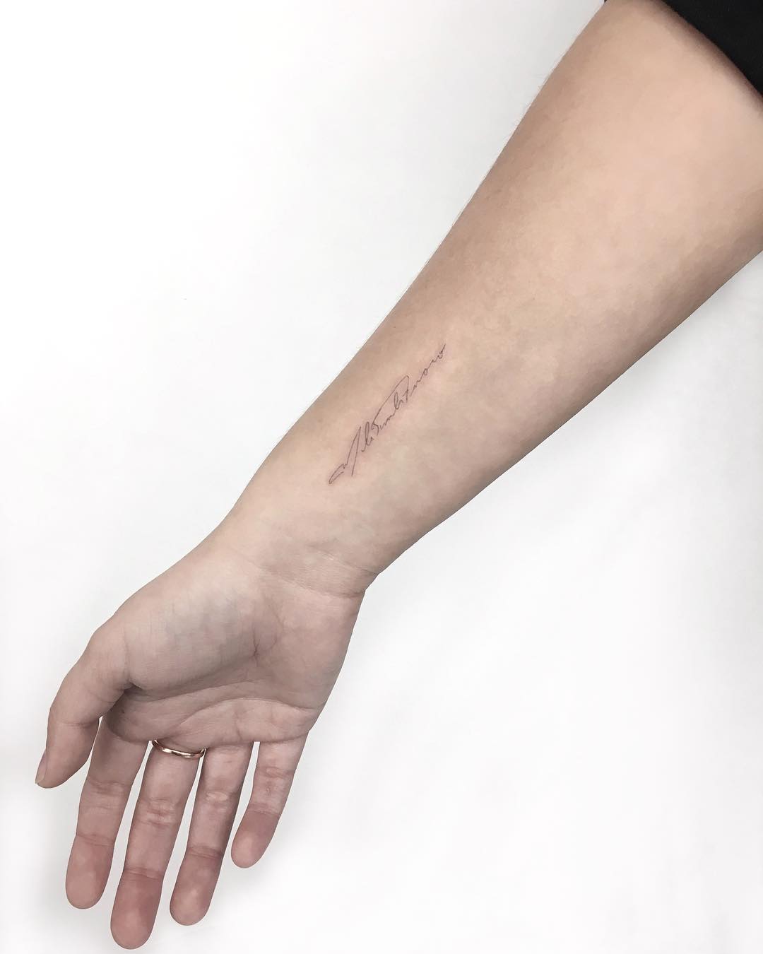 Fine line signature tattoo by Gianina Caputo