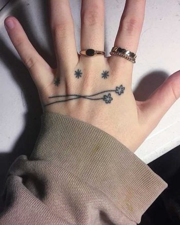 Tiny flowers on a hand by Jessica Rubbish