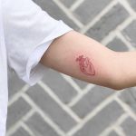 Tiny red heart tattoo by Loz Thomas