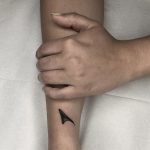 Tiny single rose thorn tattoo by Tine DeFiore