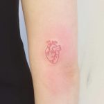 A tiny red heart tattoo by Annelie Fransson