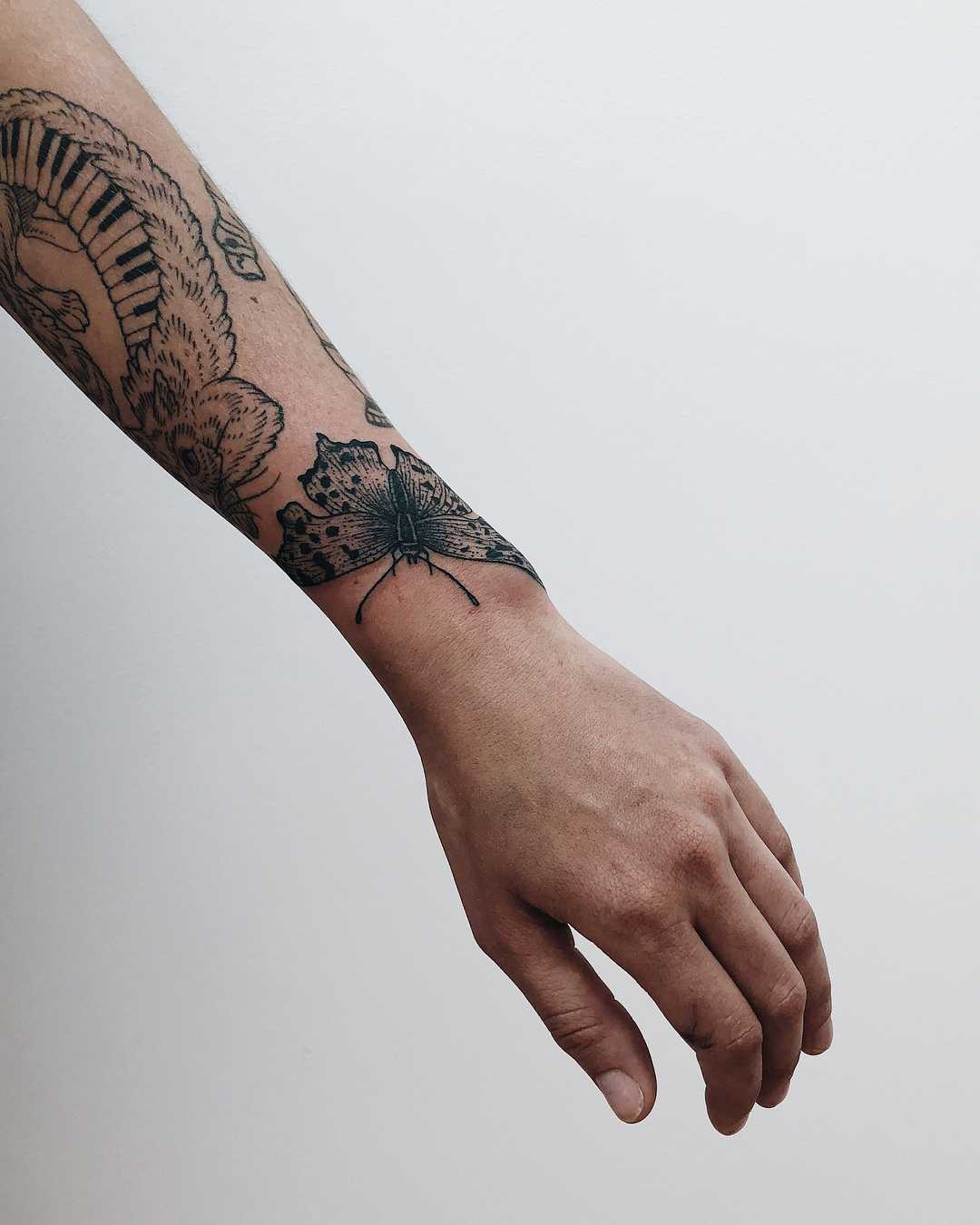 Black butterfly on the left wrist by Finley Jordan