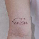 Cute lying dog tattoo by tattooist Nemo
