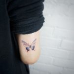 Delicate butterfly tattoo by tattooist G.NO