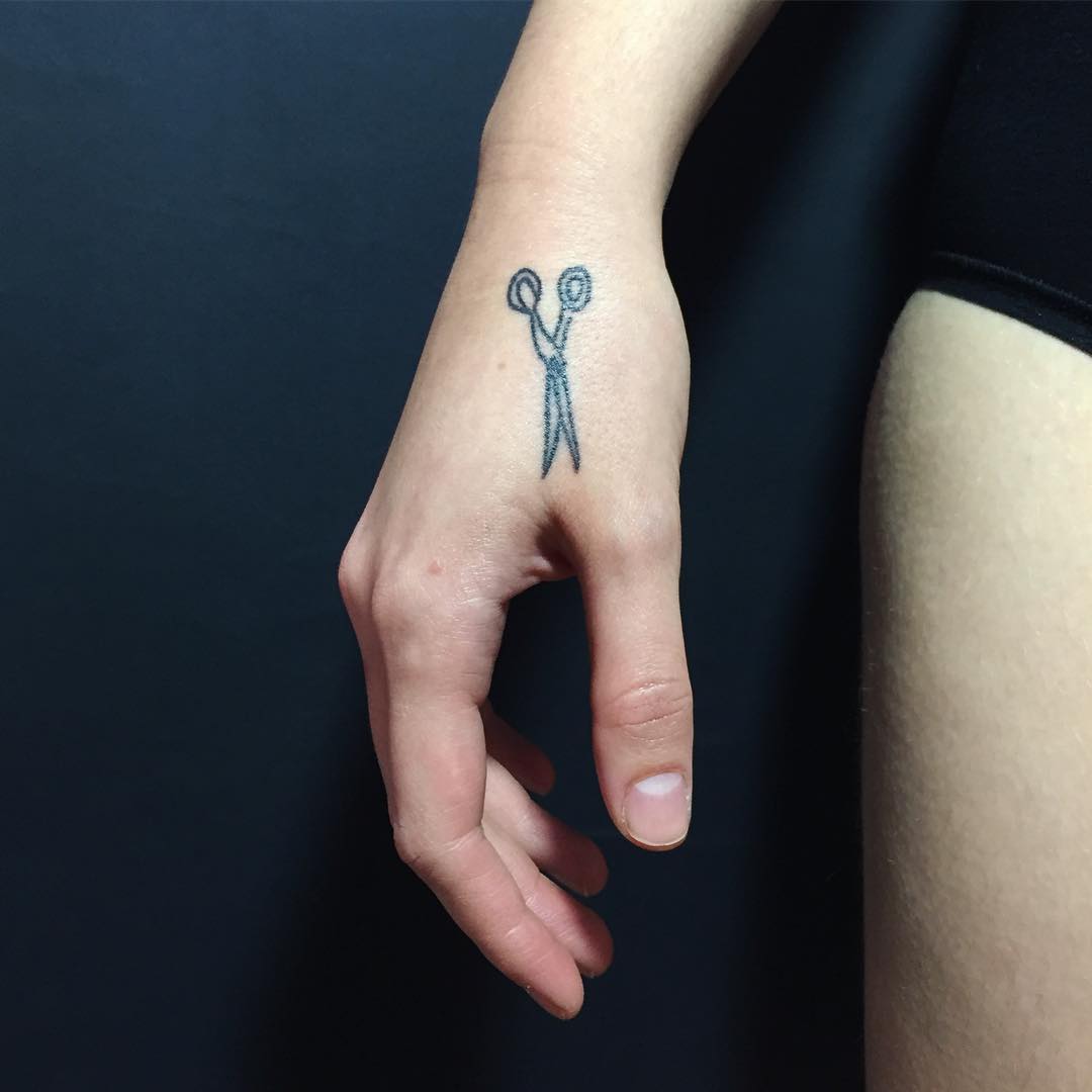 Illustrative-blackwork style scissor tattoo on the