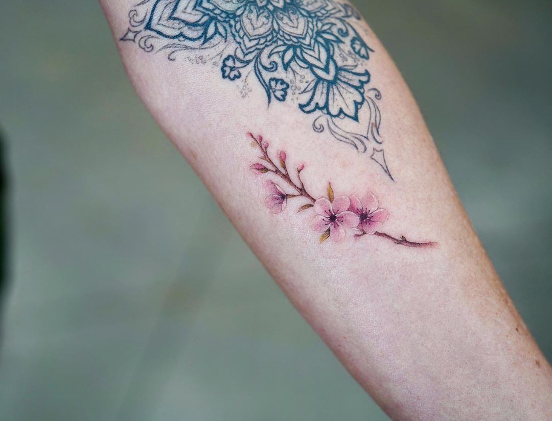 Cherry blossom branch tattoo by Dragon Ink