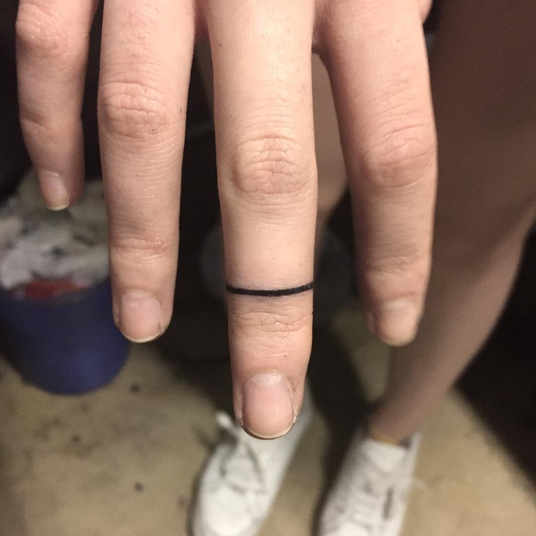Tiny black ring by tattooist yeontaan
