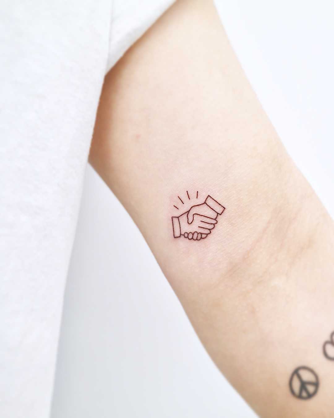 Small handshake tattoo by tattooist Nemo