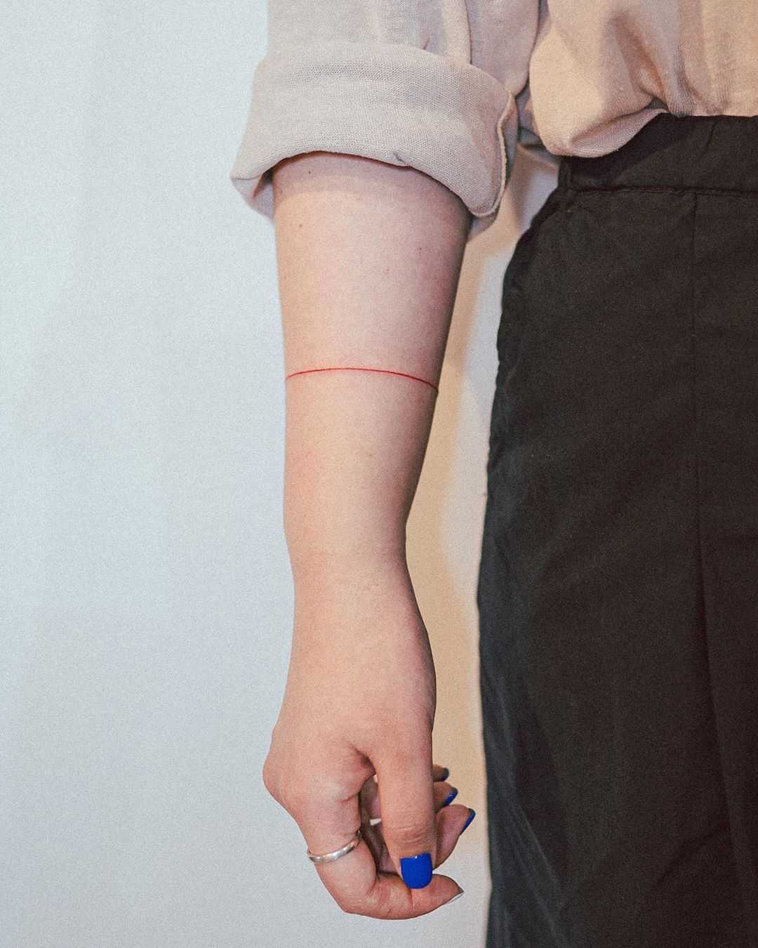 Thin red bracelet tattoo by tattooist Bongkee 