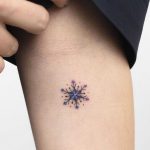 Tiny snowflake tattoo by Rey Jasper