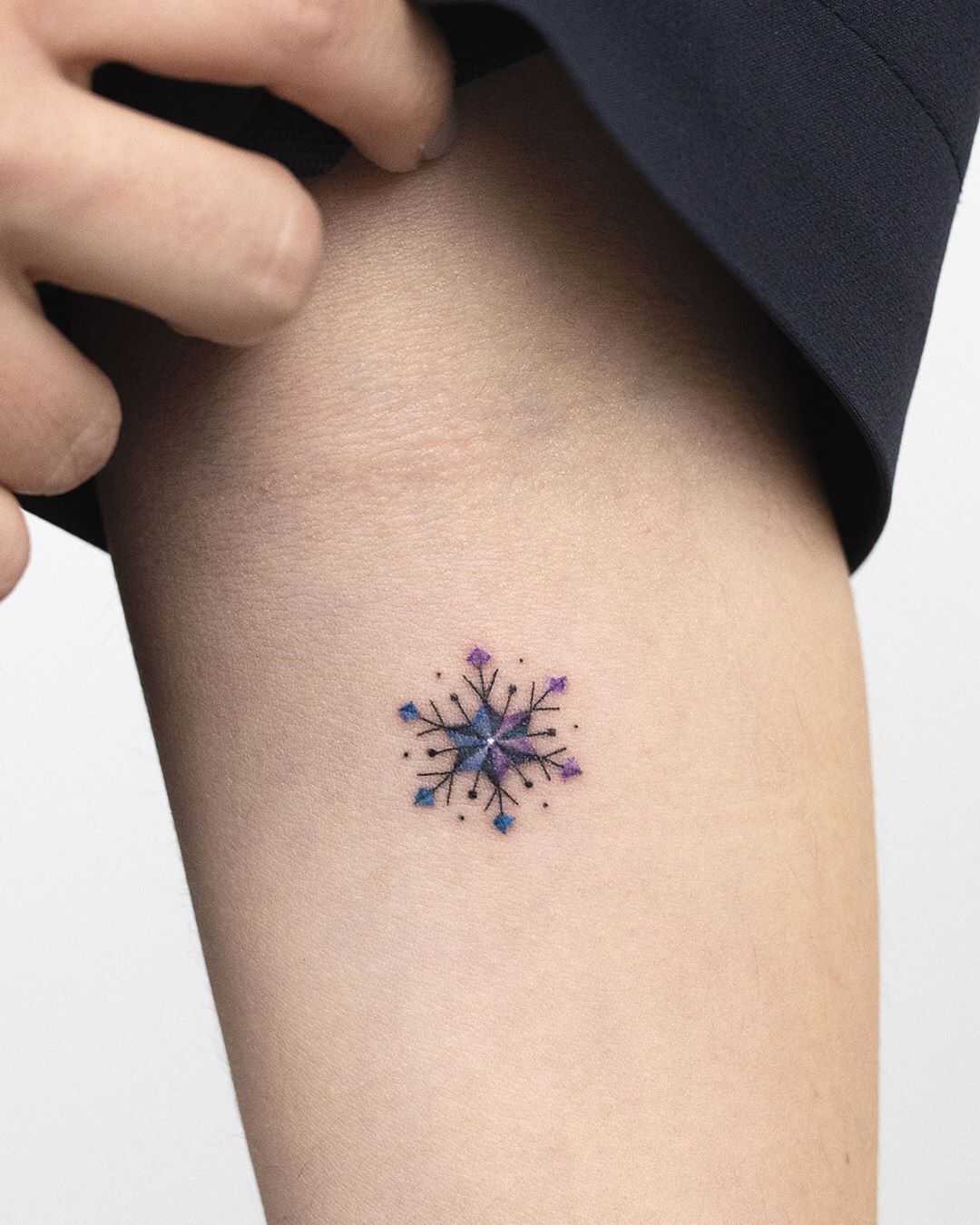 Tiny snowflake tattoo by Rey Jasper