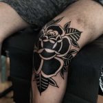 Black rose on a knee by tattooist Alejo GMZ