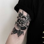 Black rose on an arm by tattooist Alejo GMZ