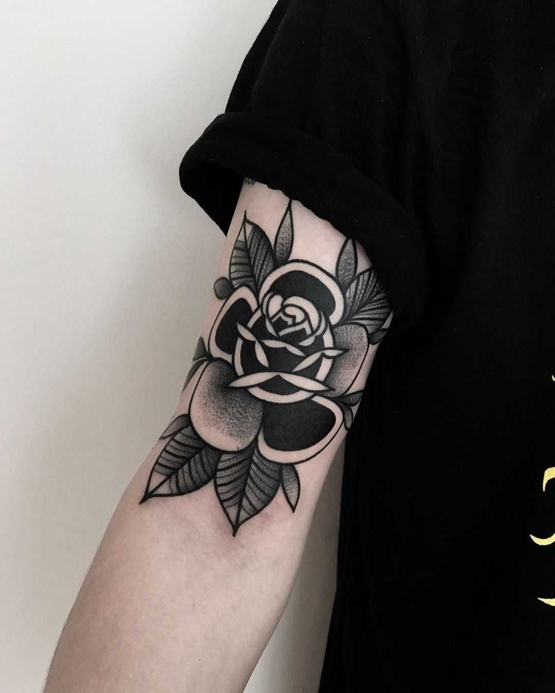 Black rose on an arm by tattooist Alejo GMZ