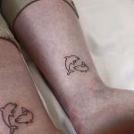 Matching dolphin tattoos by @jizottt