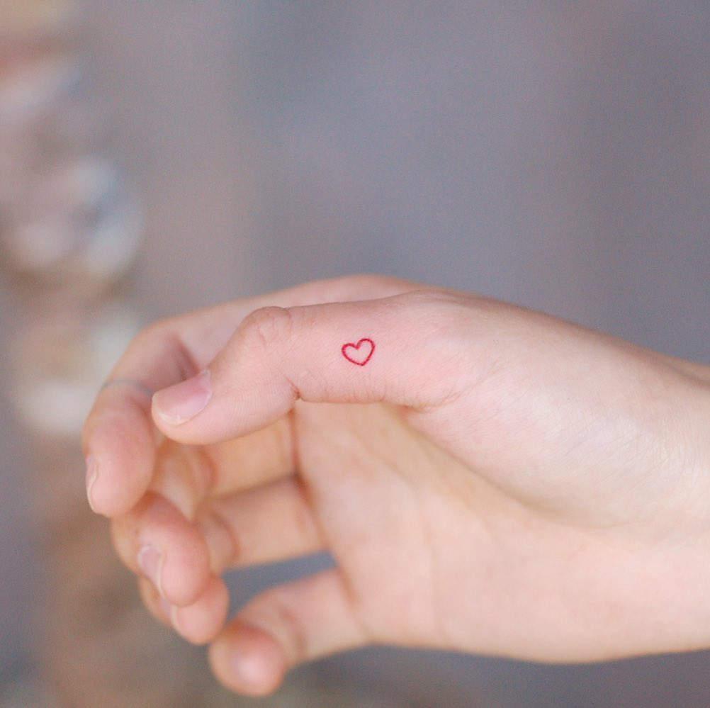 Red heart on a thumb by @wittybutton_tattoo